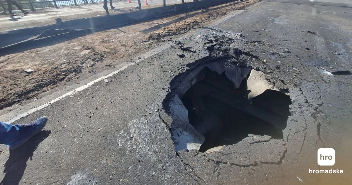 Пошкодження дорожнього полотна Північного мосту в Києві внаслідок удару російського дрона.